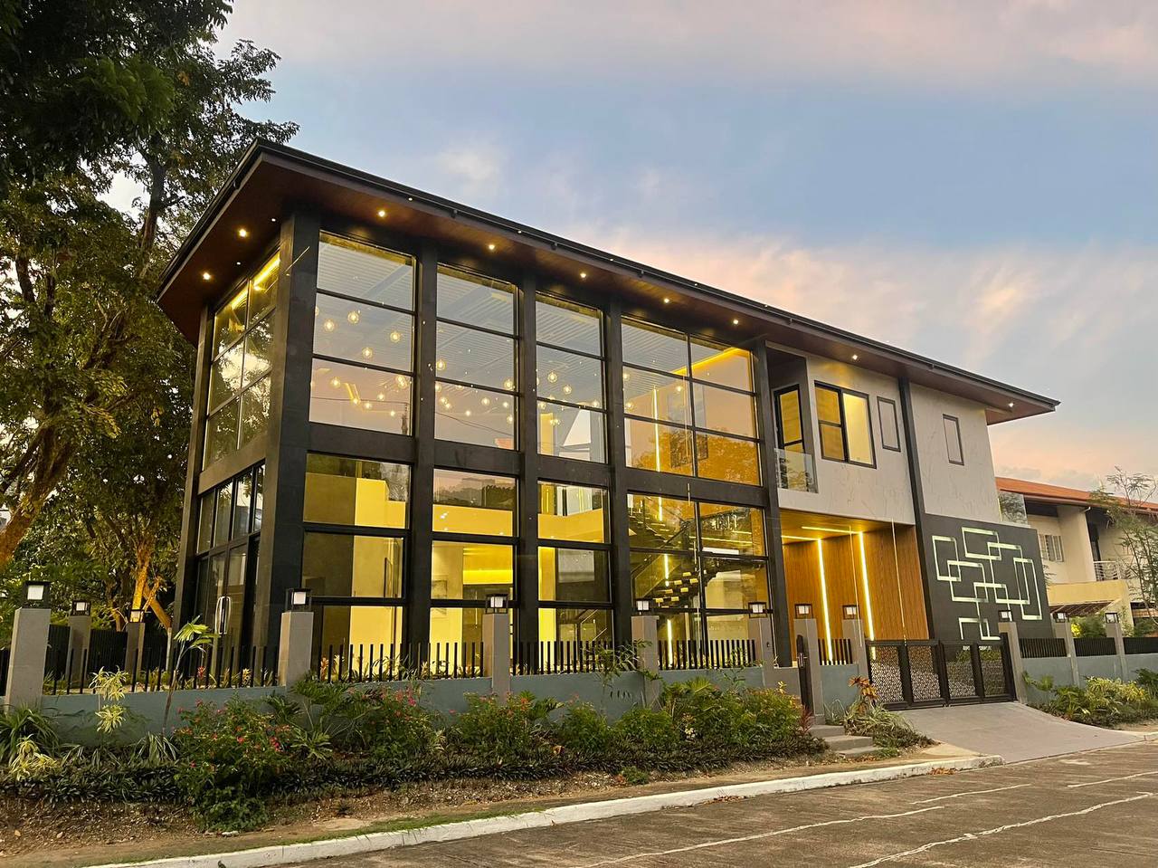 The Tierra Nueva Village Residence — illuminated glazed facade at dusk