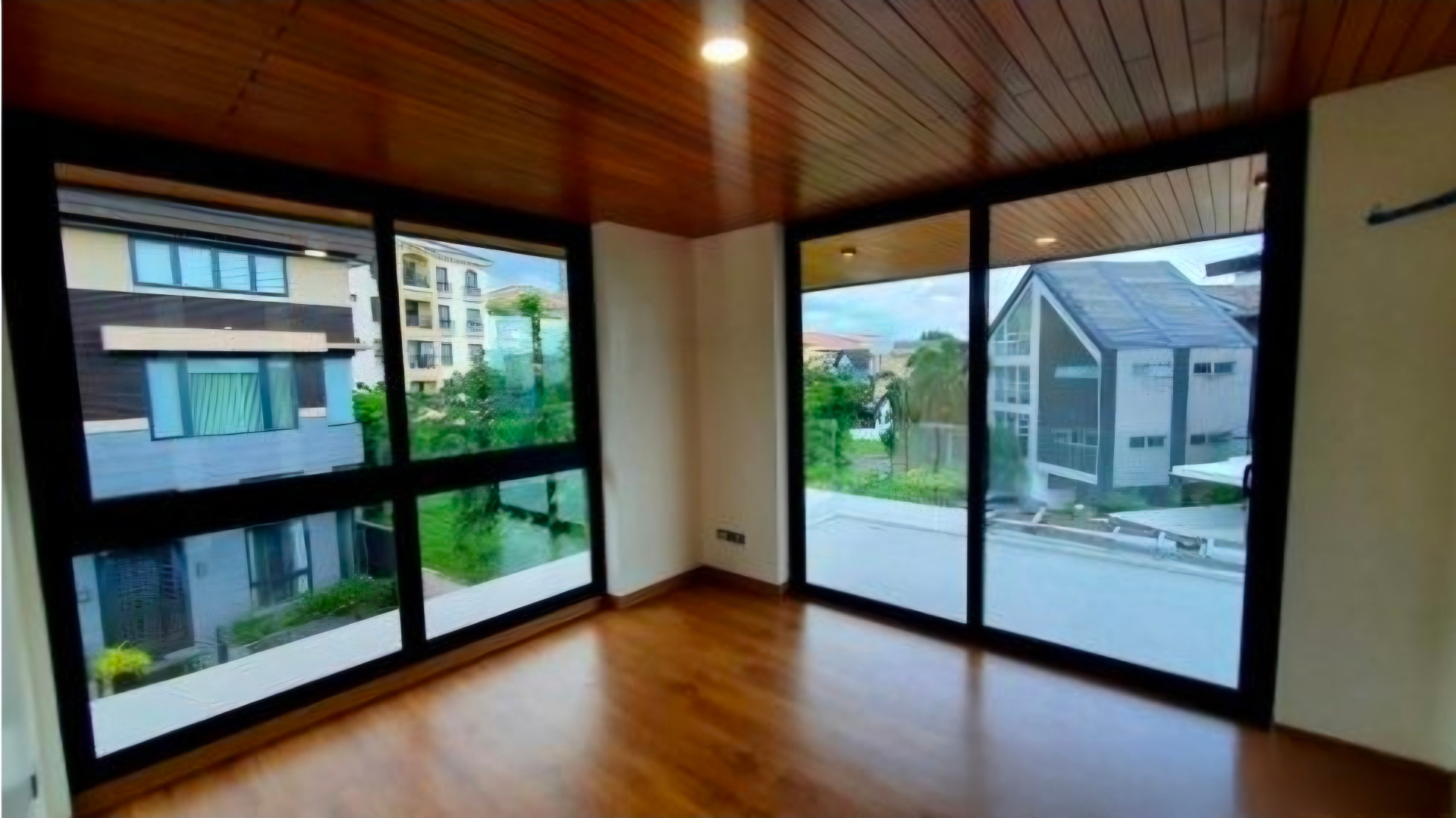 Bedroom with wraparound windows and hardwood ceiling