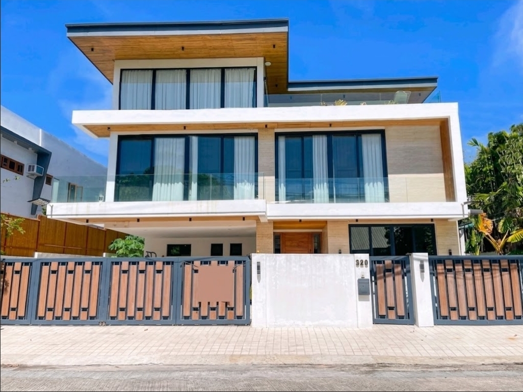 Three-storey modern Ayala Alabang facade with travertine cladding and wood soffits