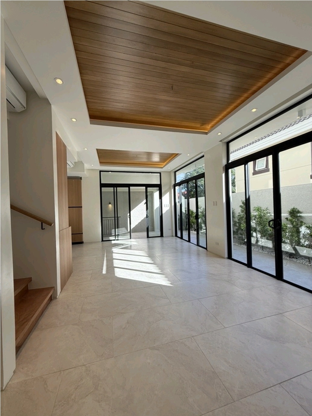 Open-plan living area with timber ceiling and full-height glass sliders