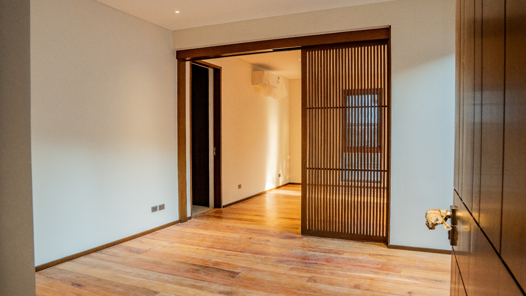 Bedroom with narra plank flooring and sliding wood slat partition