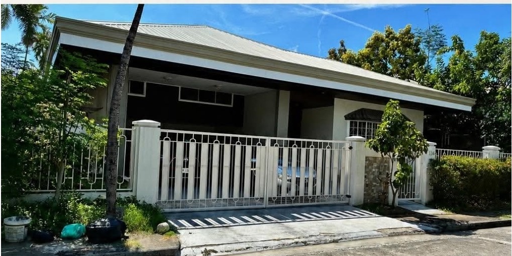 Street view of the bungalow showing the covered carport and wide frontage