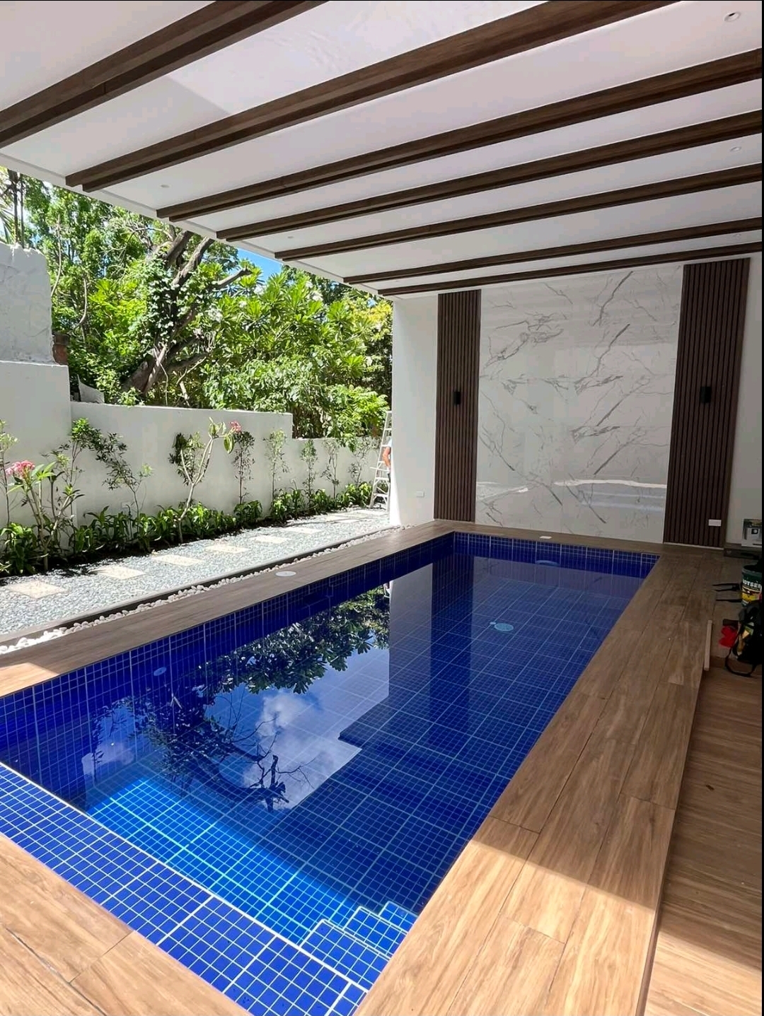 Swimming pool with timber deck and covered lanai beside the garden