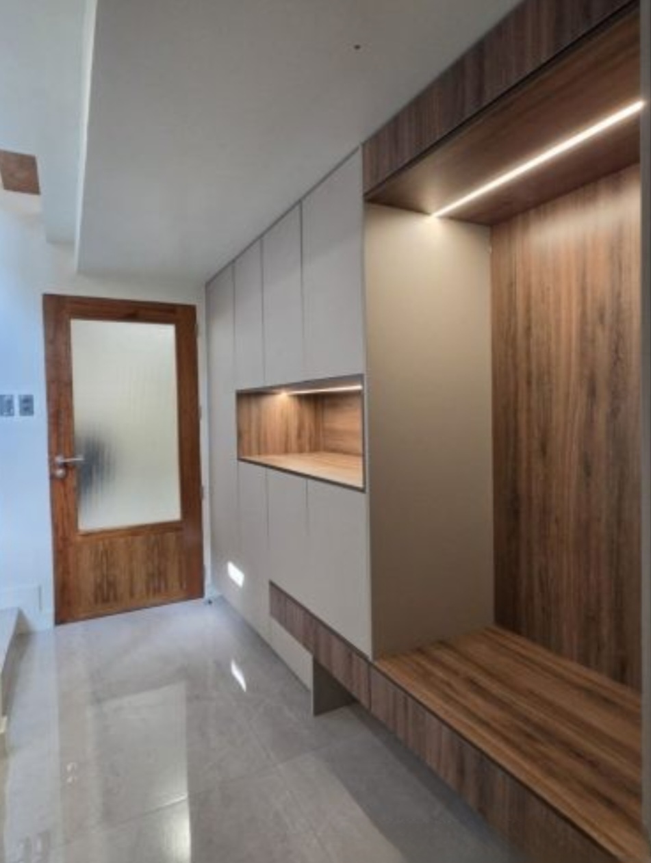Entry foyer with lit wood niches and built-in bench seating