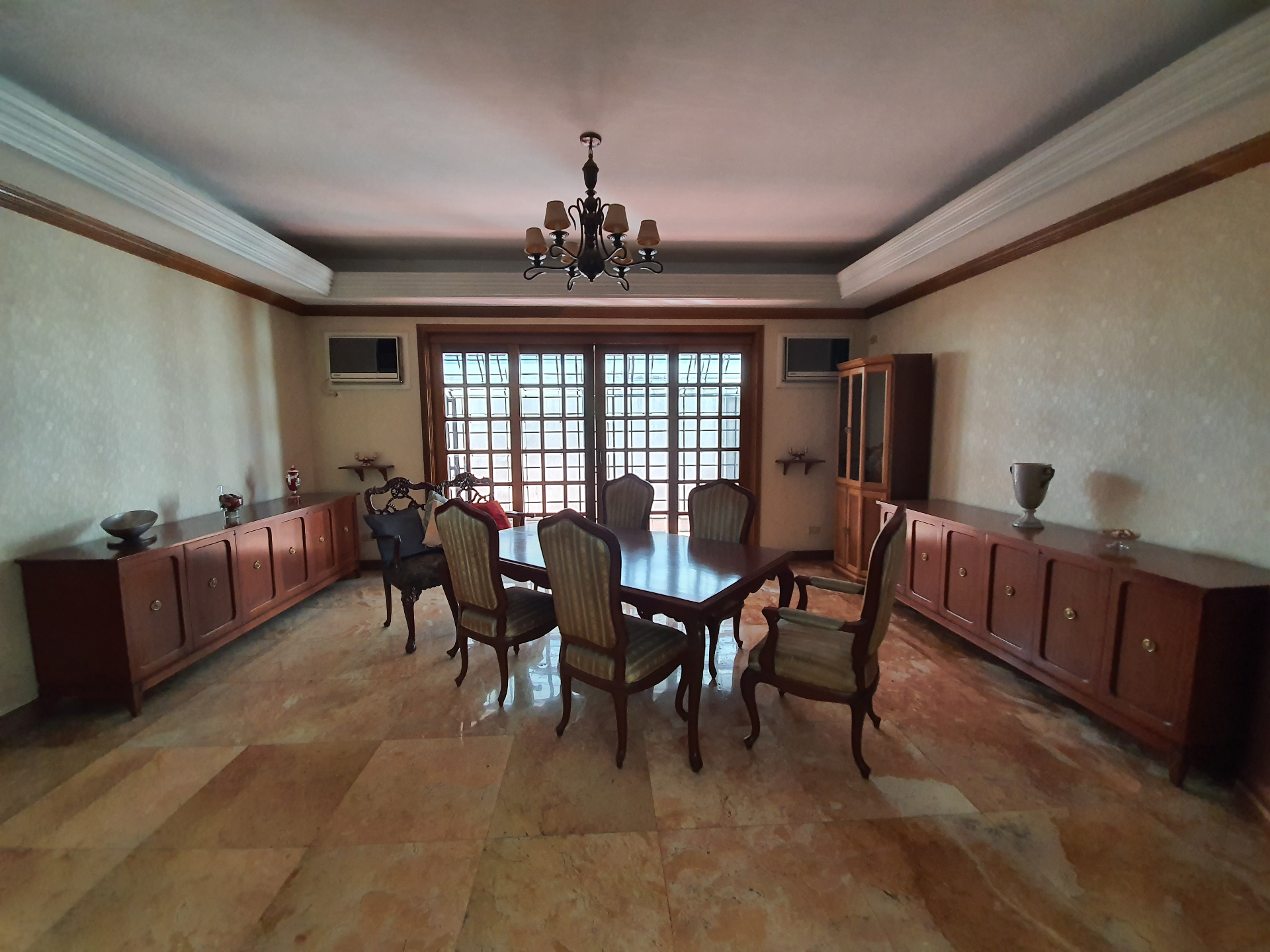 Formal dining room with chandelier and matching wood credenzas