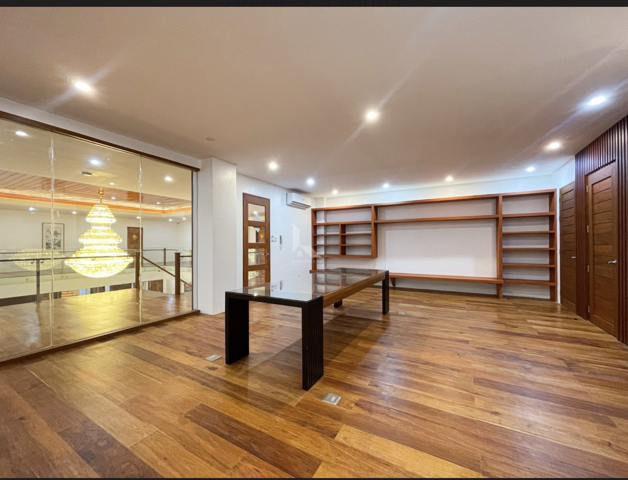 Study room with built-in hardwood shelving and glass wall to the atrium