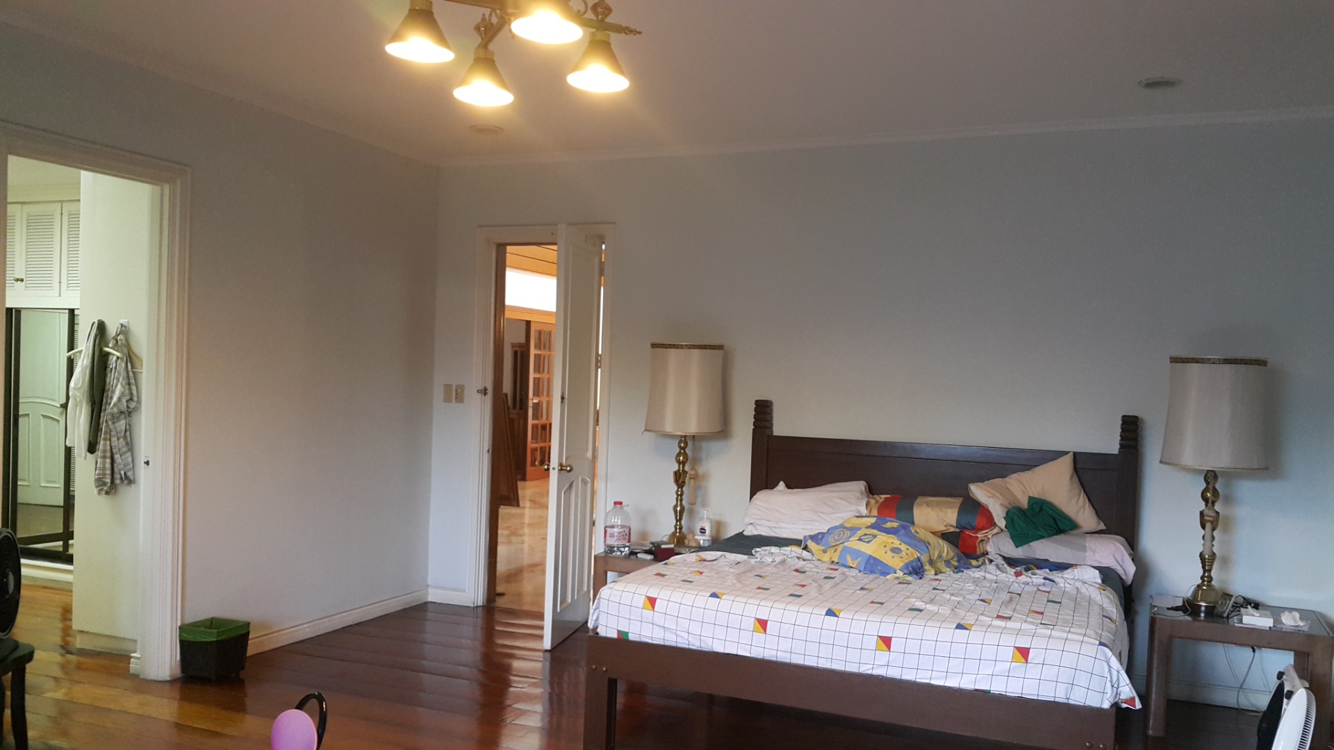 Master bedroom with hardwood floors and walk-in closet