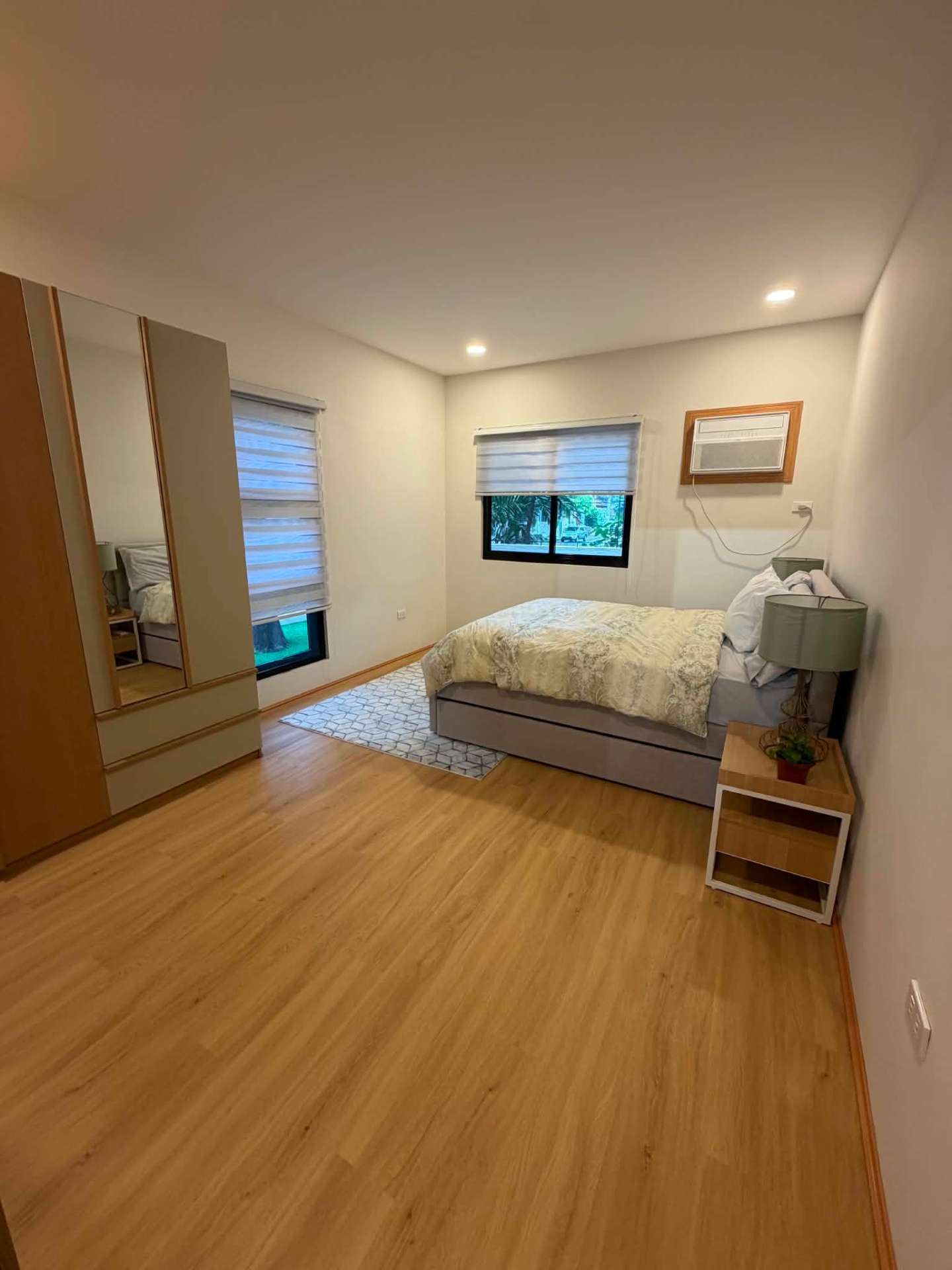 Master bedroom with mirrored built-in wardrobes and wide plank flooring