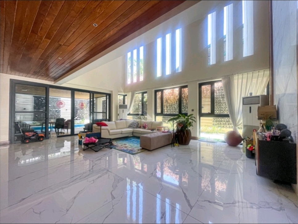 Double-height living area with hardwood cathedral ceiling and marble flooring