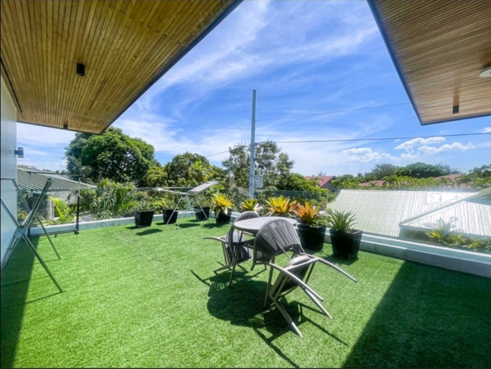 Covered roof terrace with lawn, planters and open village views