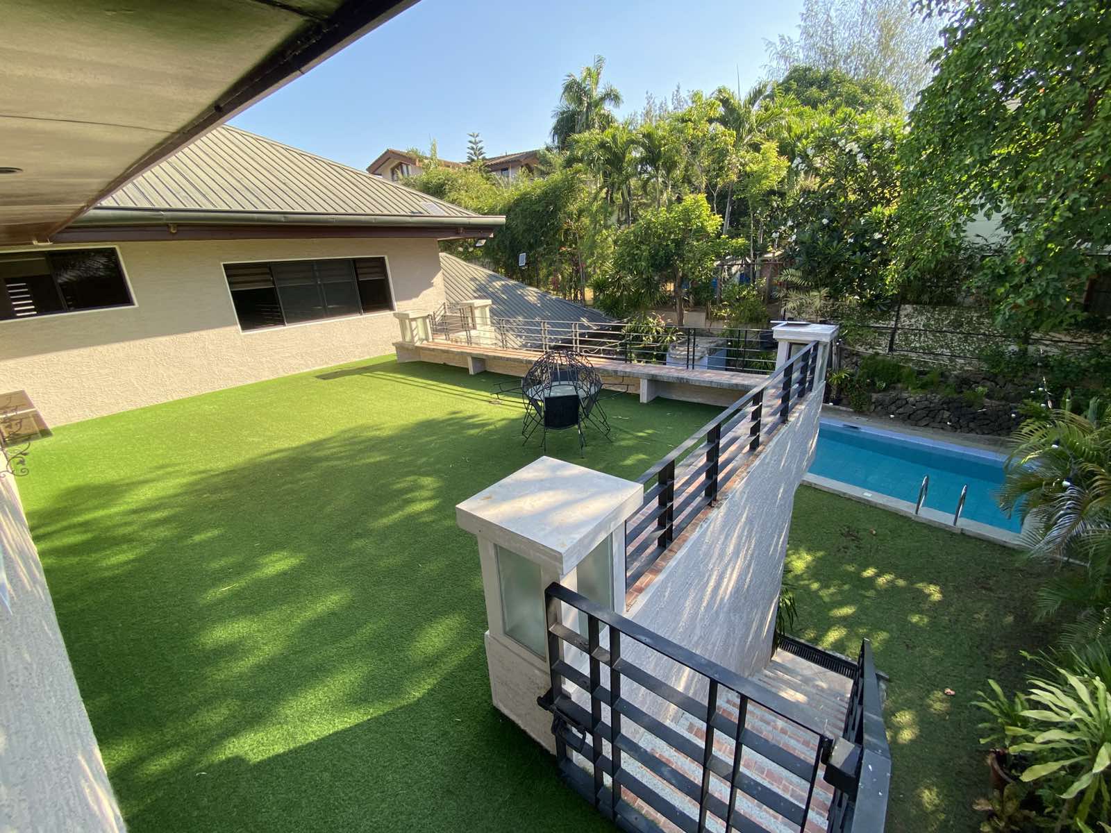Manicured lawn and swimming pool viewed from the upper balcony