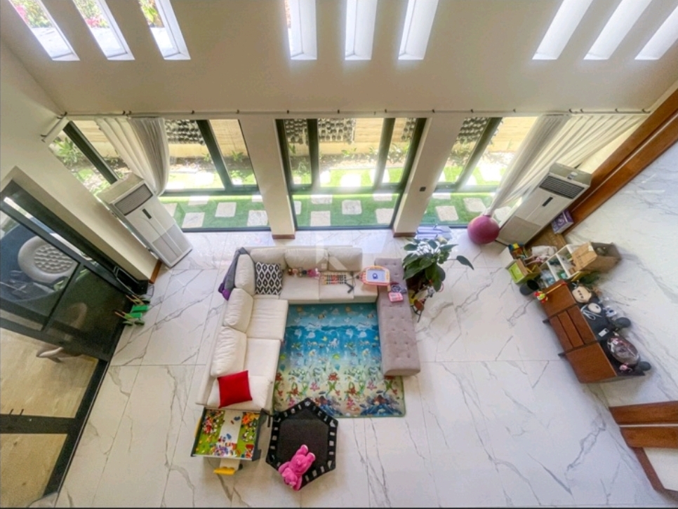 Overhead view of the living area from the mezzanine, framed by full-height glass