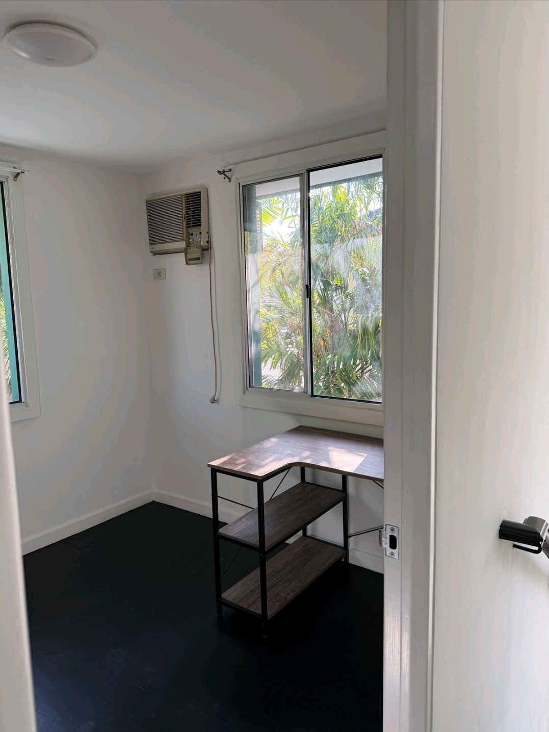 Third room set up as a home office with desk, air-conditioning and garden-facing window