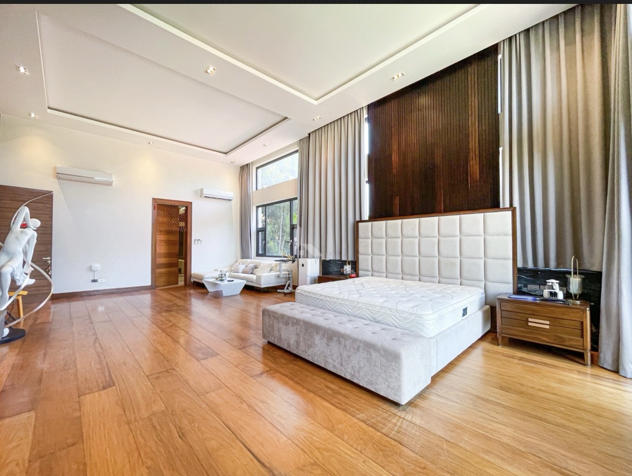 Bedroom suite with high ceiling and hardwood flooring