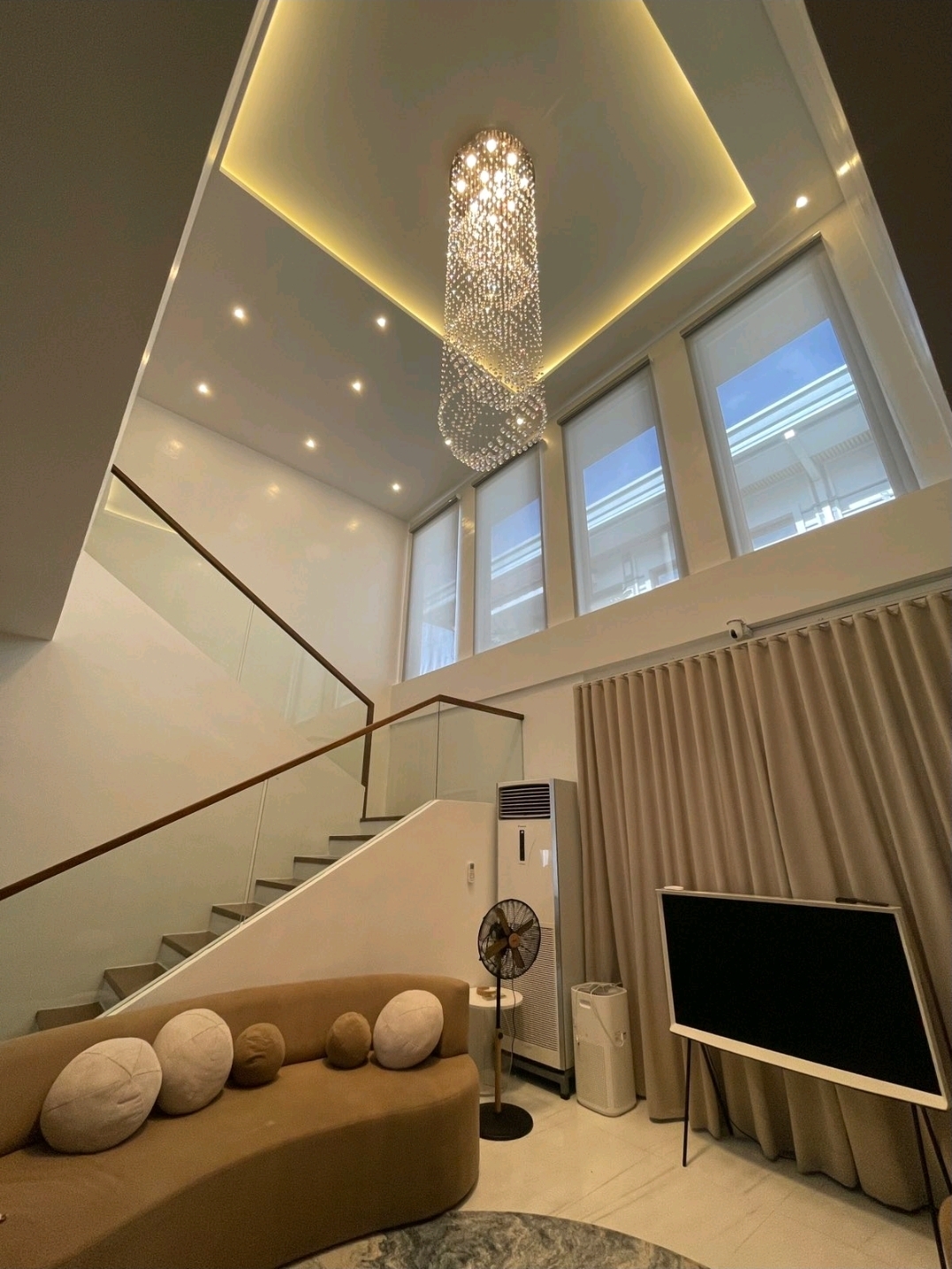 Staircase with glass railing beside the living area