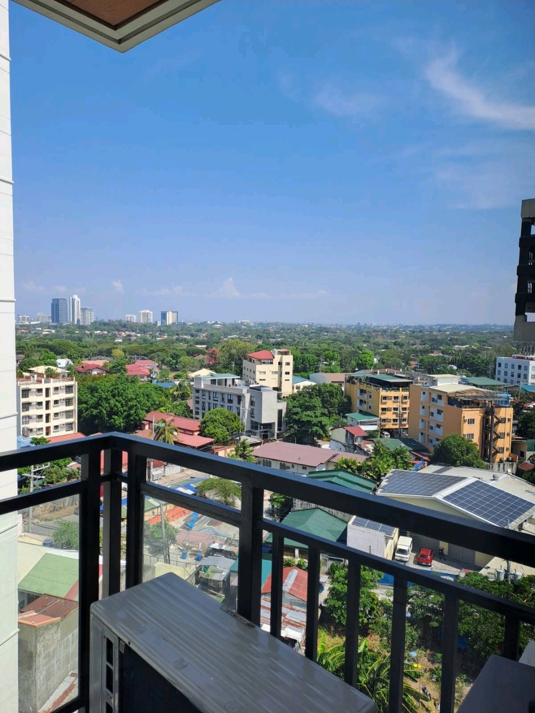 Balcony view over village greenery and city buildings