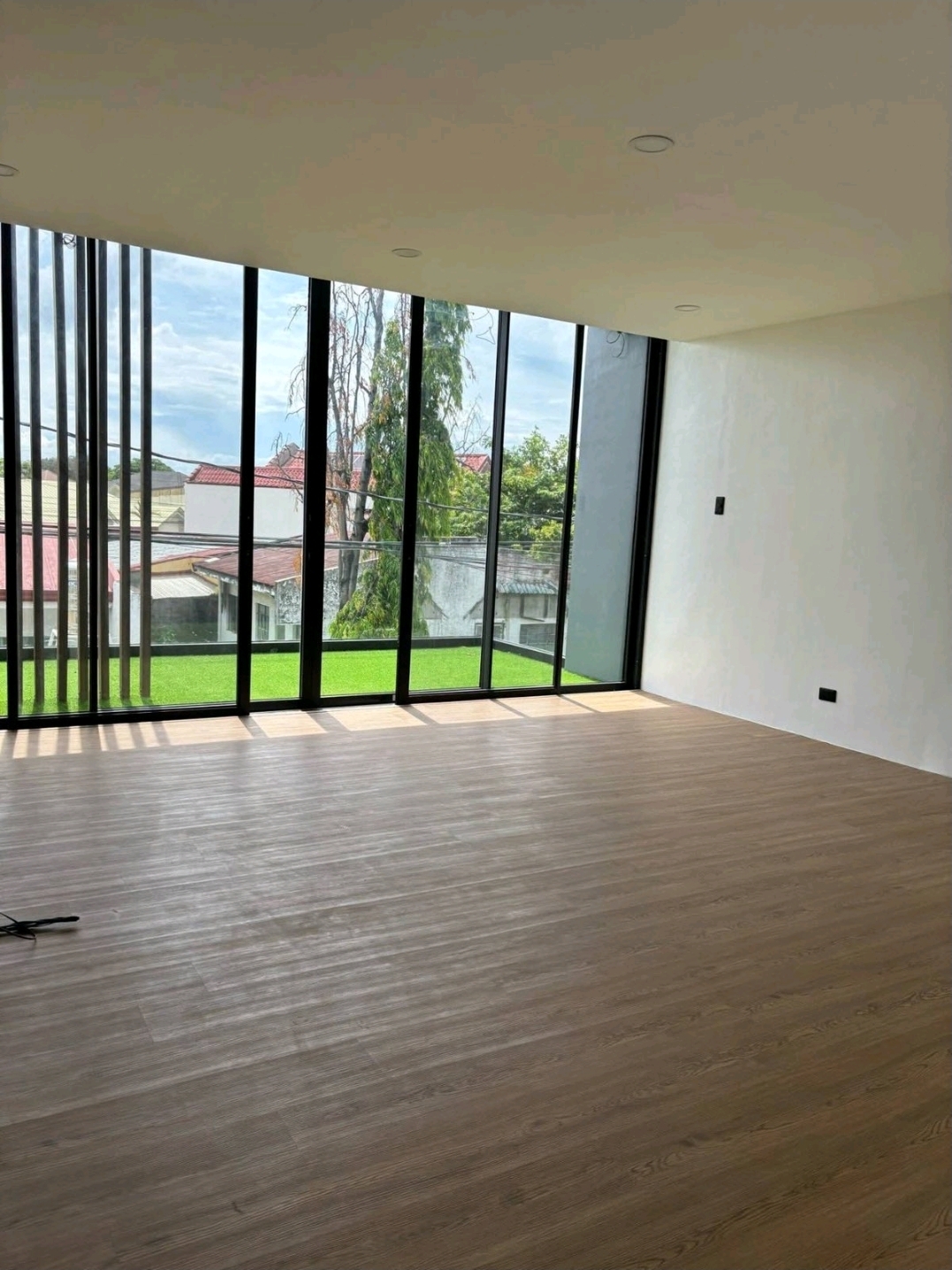 Corner bedroom with floor-to-ceiling glazing and vinyl plank flooring
