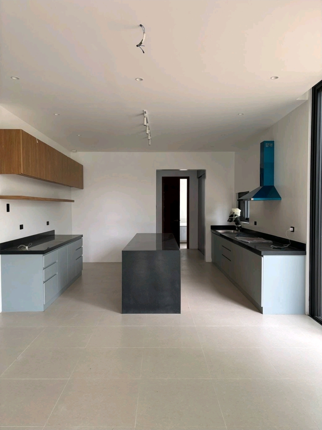 Modular main kitchen with island, stone counters, and range hood