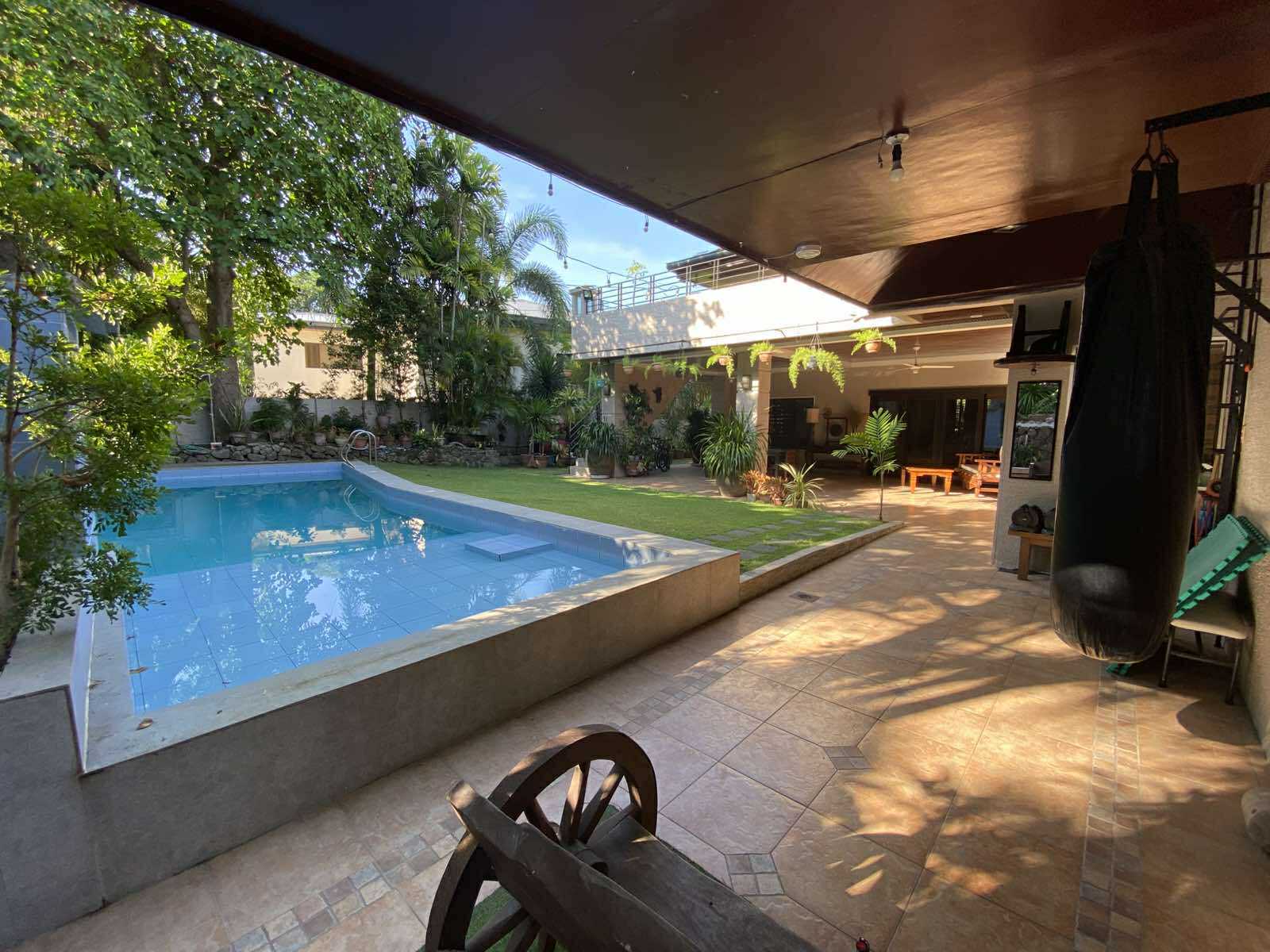 Covered lanai looking across the swimming pool and lawn