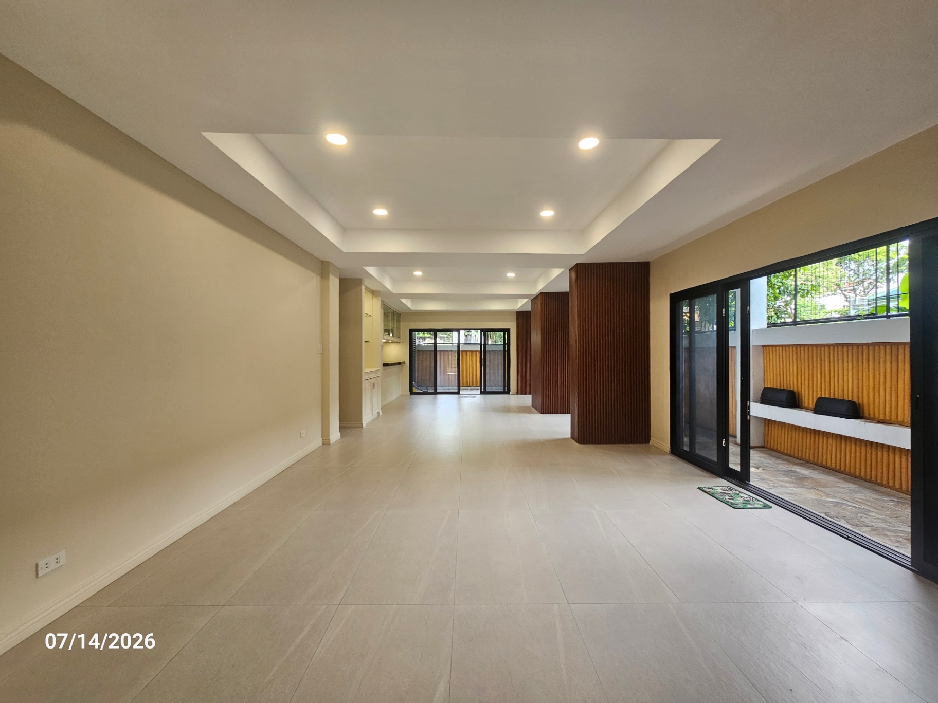 Ground-floor living area opening to a covered lanai and garden