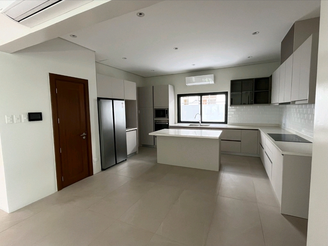 Modern kitchen with island counter, built-in appliances and service door
