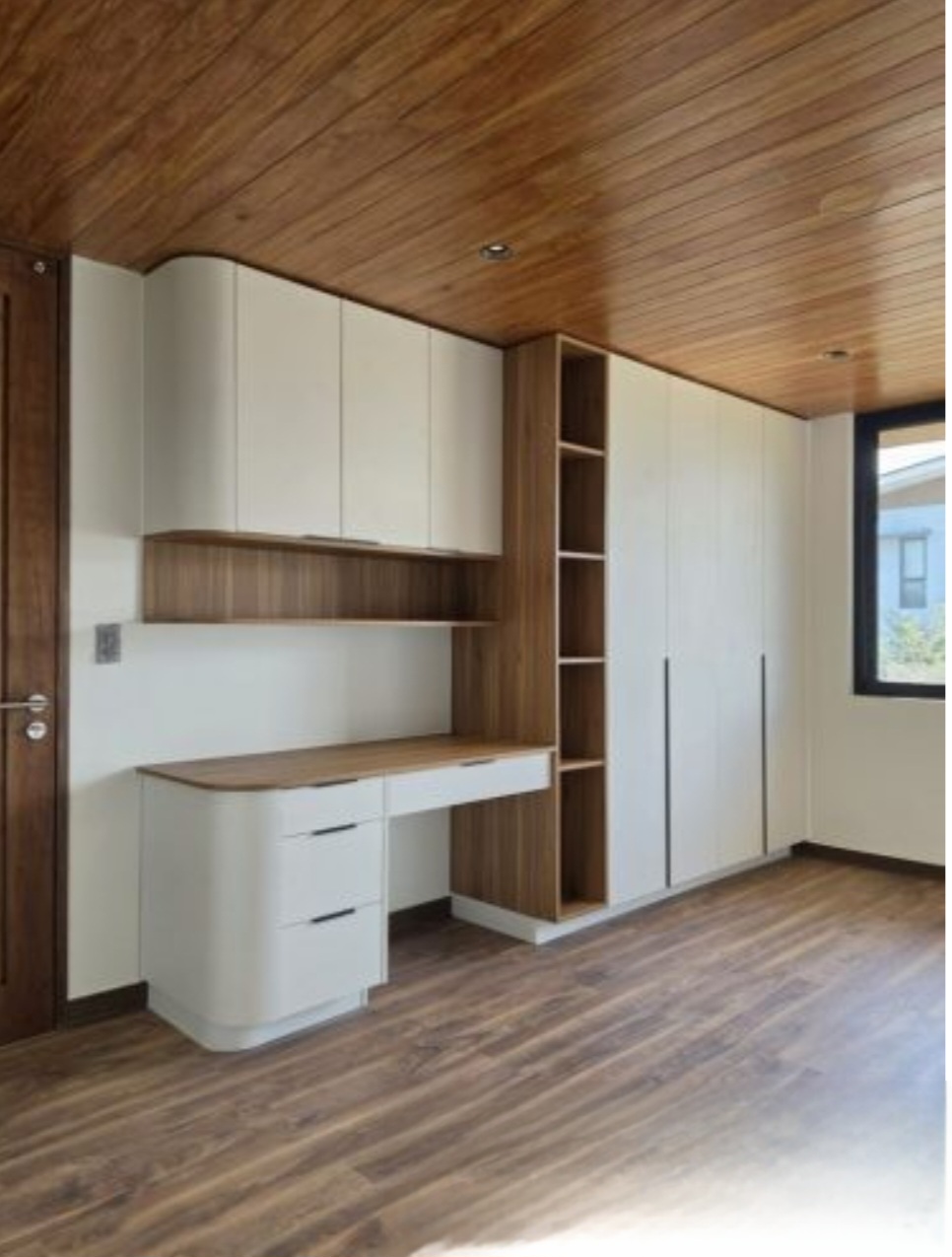 Bedroom with built-in study desk and full-height wardrobes