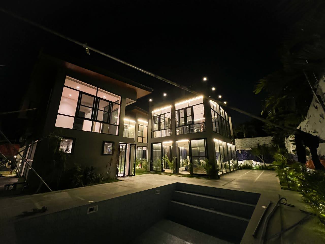 The Ayala Alabang Modern Manor — illuminated contemporary facade above the pool