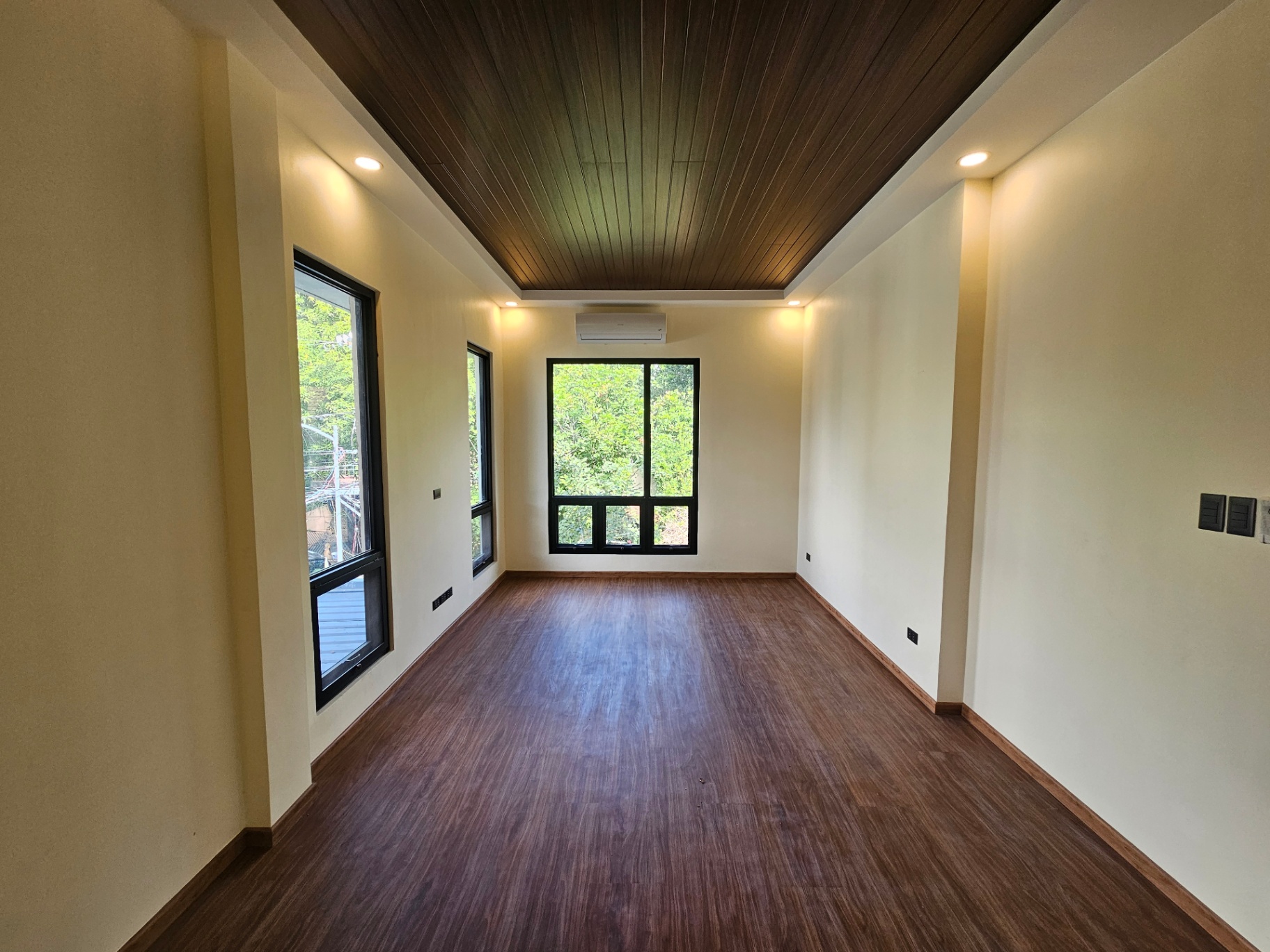 Master bedroom with timber-lined dropped ceiling and wood-look plank flooring