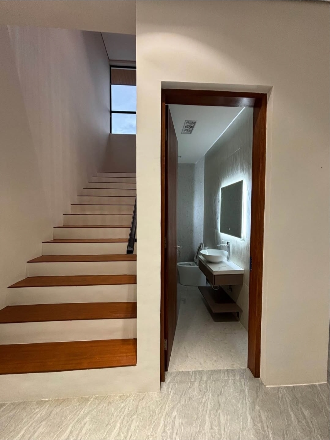 Guest powder room with backlit mirror and floating vanity