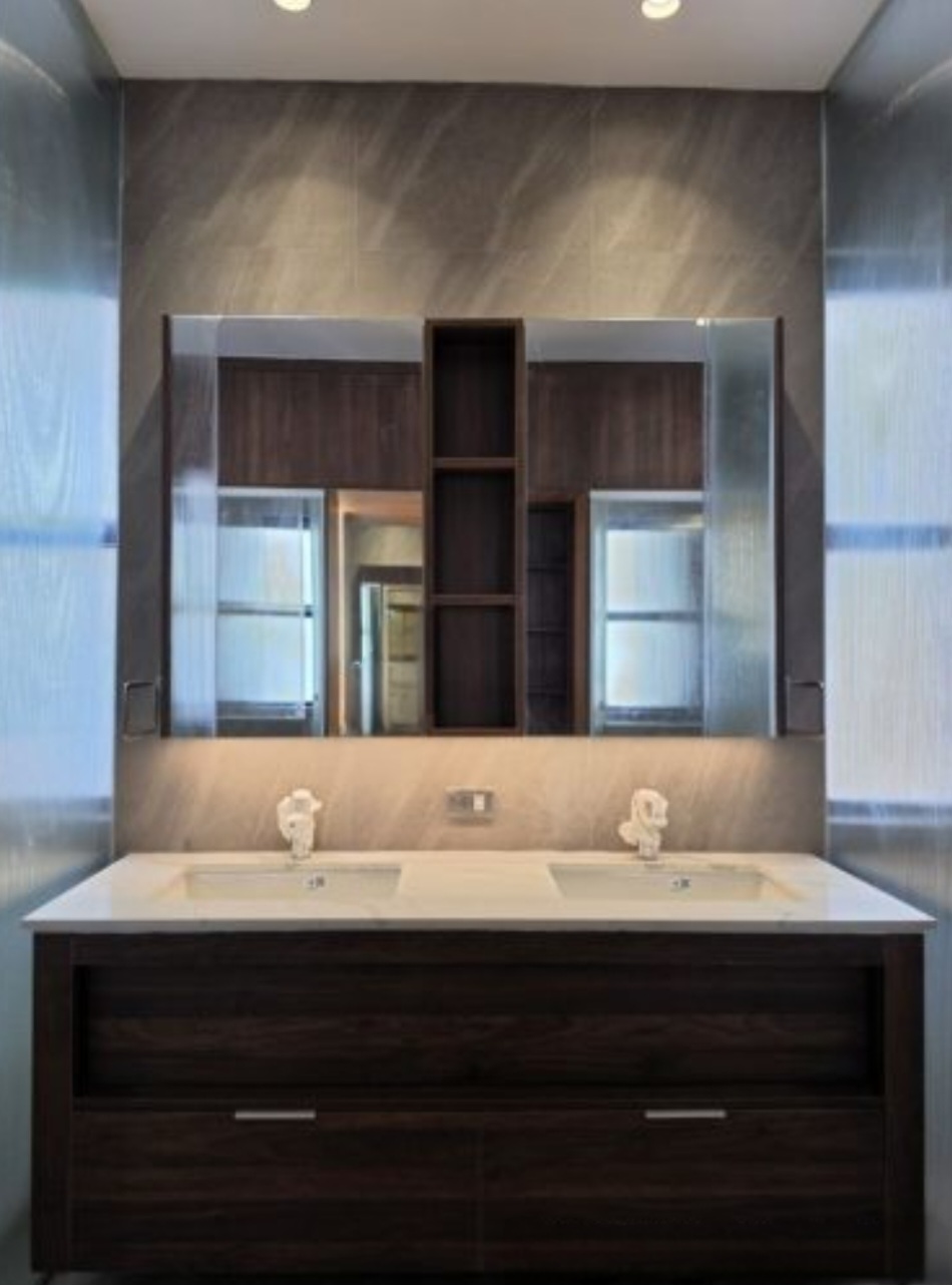 Master bath with stone walls and marble double vanity