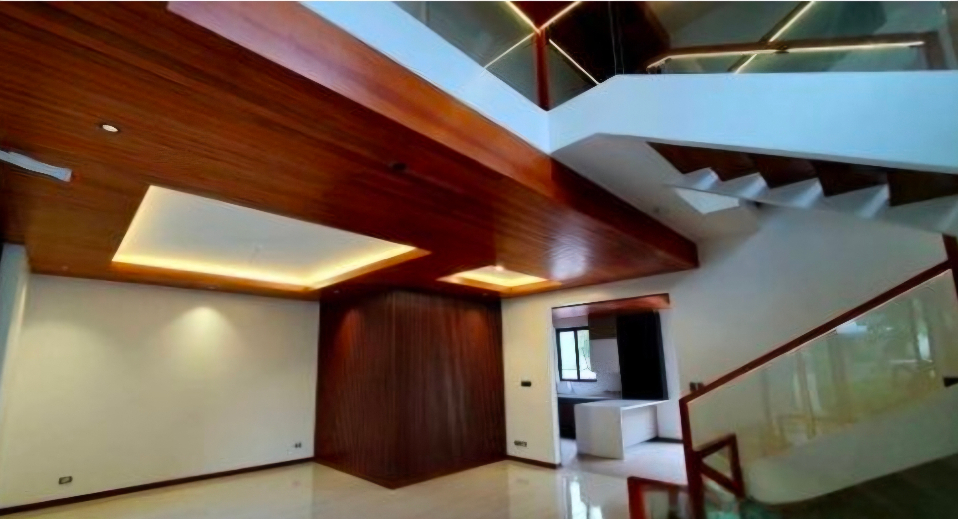 Double-height living area beneath a warm hardwood ceiling