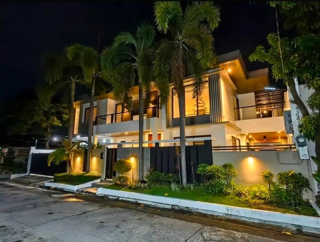 Illuminated facade of the BF Homes corner residence in Parañaque at night